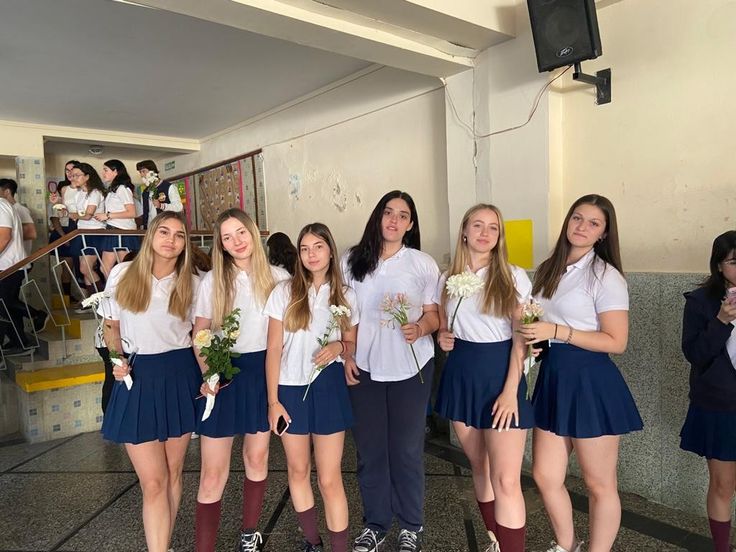 Grupo de estudiantes con el uniforme escolar típico de falda azul y polo blanco en un instituto durante su año escolar en Irlanda.