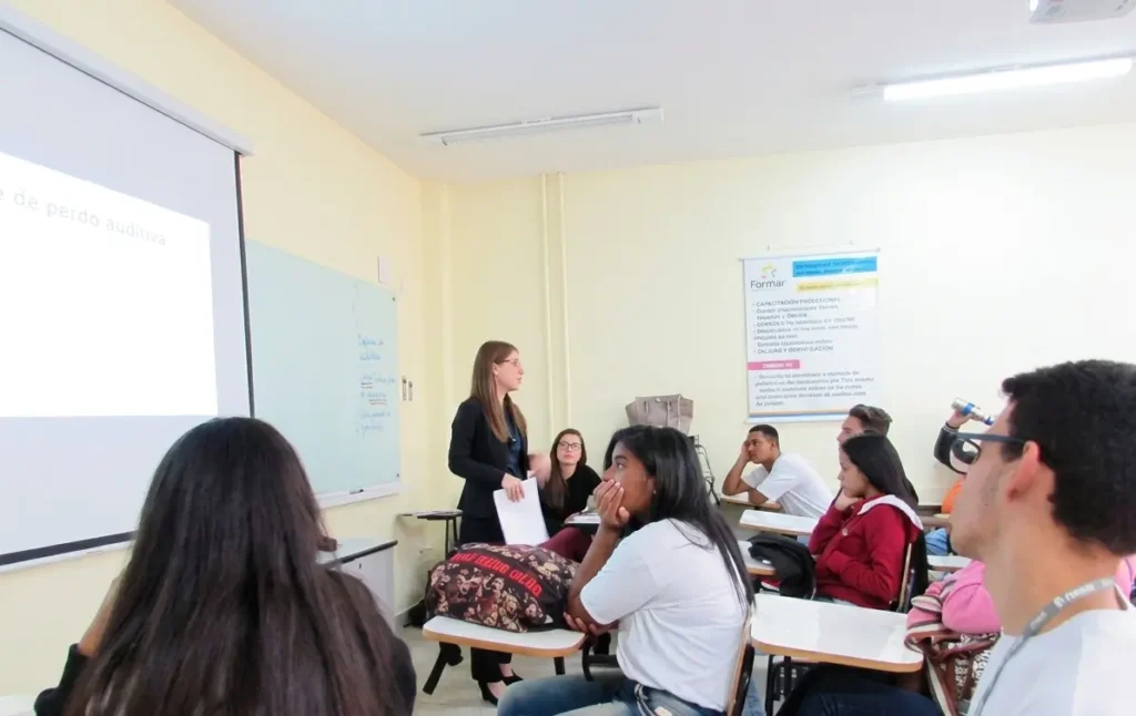 Profesora impartiendo una clase de presentación y reuniones de negocios en un curso de inglés en el extranjero para adultos.